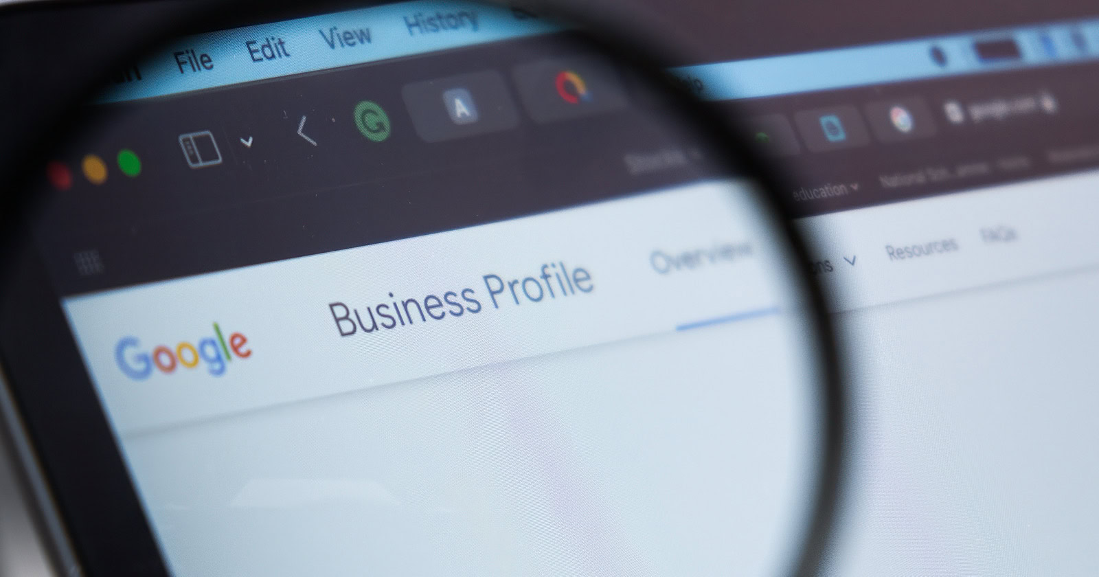 Google Business Profile logo on the screen of laptop through magnifying glass,